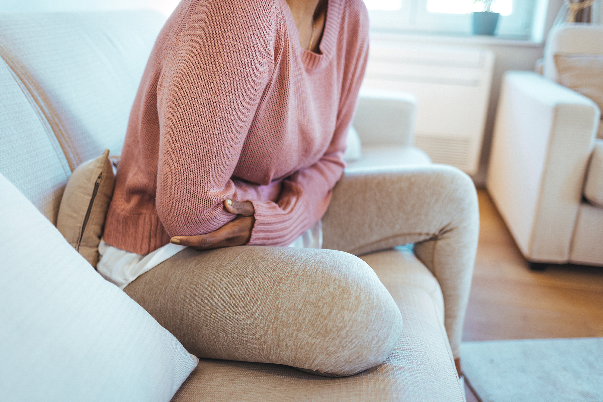 Photo of woman with irritable bowel syndrome clutching her gut in pain.